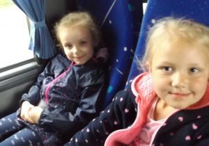 dwie dziewczynki siedzą obok siebie w autokarze jadąc na wycieczkę